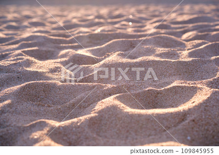 Close up of clean yellow sand surface covering seaside beach illuminated with evening light. Travel and vacations concept 109845955