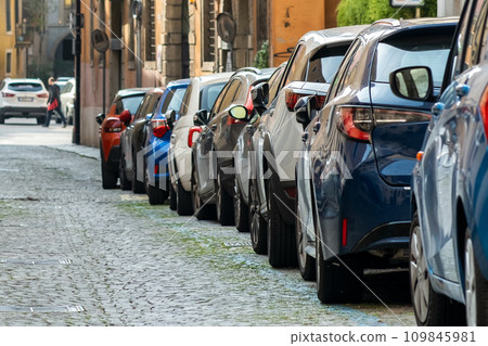 Modern cars parked on city street side in residential discrict. Shiny vehicles parked by the curb. Urban transportation infrastructure concept. 109845981