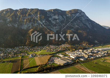Aerial view of green meadows with villages and forest in austrian Alps mountains. Aerial view of green meadows with villages and forest in austrian Alps mountains. 109846071