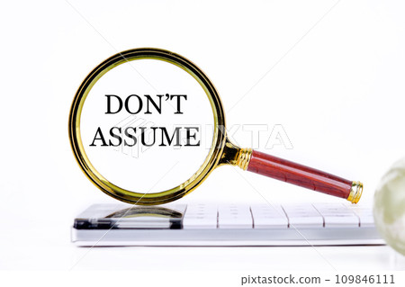 DO NOT ASSUME lettering through a magnifying glass on a calculator and part of a magic ball in the foreground without focus 109846111