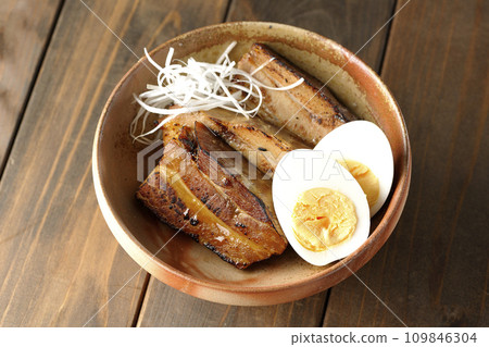 An overhead shot of thickly sliced char siu topped with white onion and boiled egg An overhead shot of thickly sliced char siu topped with white onion and boiled egg 109846304