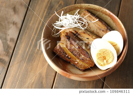 An overhead shot of thickly sliced char siu topped with white onion and boiled egg An overhead shot of thickly sliced char siu topped with white onion and boiled egg 109846311