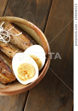 An overhead shot of thickly sliced char siu topped with white onion and boiled egg An overhead shot of thickly sliced char siu topped with white onion and boiled egg 109846323