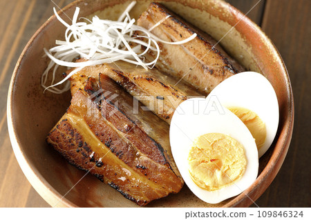 An overhead shot of thickly sliced char siu topped with white onion and boiled egg An overhead shot of thickly sliced char siu topped with white onion and boiled egg 109846324