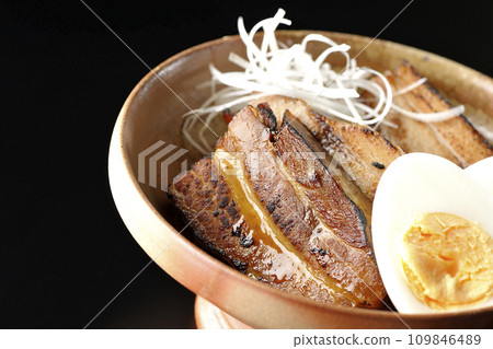 Thickly sliced char siu topped with white onion and boiled egg photographed against a black background Thickly sliced char siu topped with white onion and boiled egg photographed against a black background 109846489