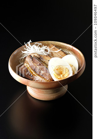 Thickly sliced char siu topped with white onion and boiled egg photographed against a black background Thickly sliced char siu topped with white onion and boiled egg photographed against a black background 109846497