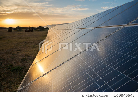 Solar panels, photovoltaics, alternative source of electricity - concept of sustainable and renewable sources. Low light morning down shot with natural sun reflection and dew drops. Selective focus. Solar panels, photovoltaics, alternative source of electricity - concept of sustainable and renewable sources. Low light morning down shot with natural sun reflection and dew drops. Selective focus. 109846643