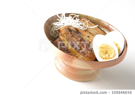 厚切的叉燒,上面放著白洋蔥和煮雞蛋,在白色背景下拍照 厚切的叉燒,上面放著白洋蔥和煮雞蛋,在白色背景下拍照 109846656