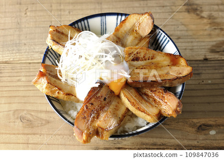 An overhead shot of thick-sliced char siu rice topped with a soft-boiled egg 109847036
