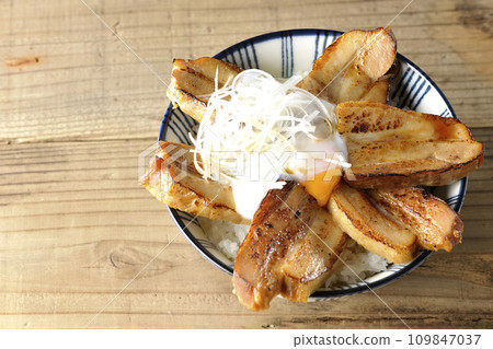 頭頂上放著厚片叉燒飯，上面放著一個半熟的雞蛋 109847037