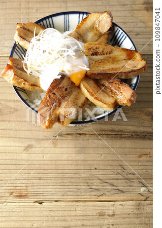 An overhead shot of thick-sliced char siu rice topped with a soft-boiled egg 109847041