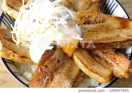 An overhead shot of thick-sliced char siu rice topped with a soft-boiled egg 109847045