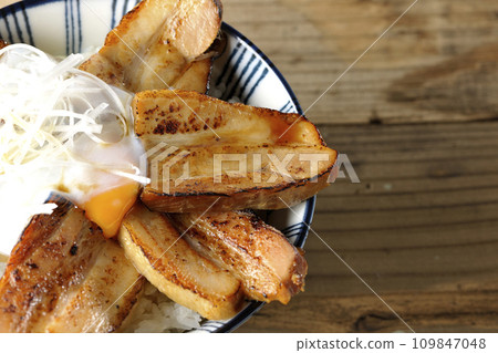 An overhead shot of thick-sliced char siu rice topped with a soft-boiled egg 109847048