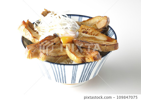 Thick-sliced char siu bowl topped with a soft-boiled egg photographed against a white background Thick-sliced char siu bowl topped with a soft-boiled egg photographed against a white background 109847075