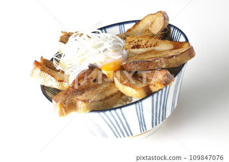 Thick-sliced char siu bowl topped with a soft-boiled egg photographed against a white background 109847076