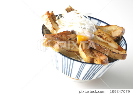 Thick-sliced char siu bowl topped with a soft-boiled egg photographed against a white background 109847079