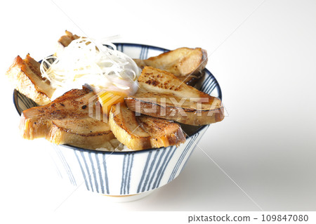 Thick-sliced char siu bowl topped with a soft-boiled egg photographed against a white background 109847080