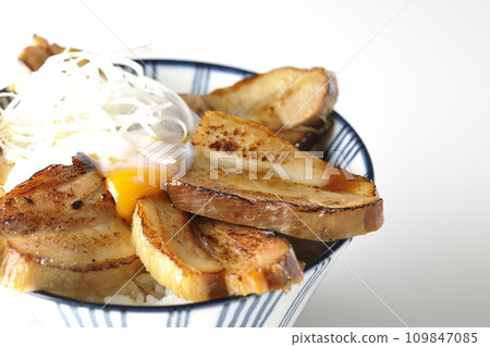 Thick-sliced char siu bowl topped with a soft-boiled egg photographed against a white background 109847085