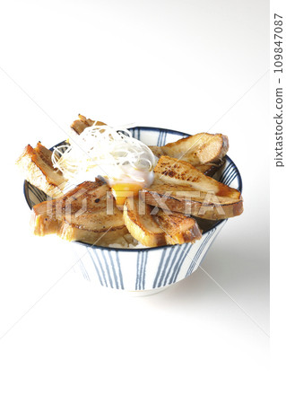 Thick-sliced char siu bowl topped with a soft-boiled egg photographed against a white background 109847087