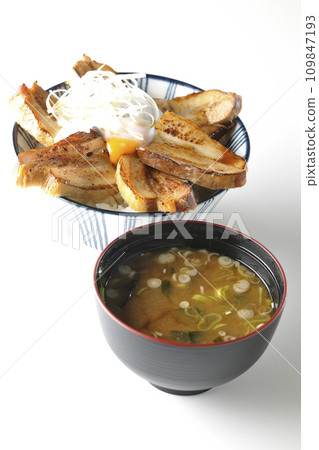 Thick-sliced roasted pork bowl topped with soft-boiled egg and miso soup 109847193