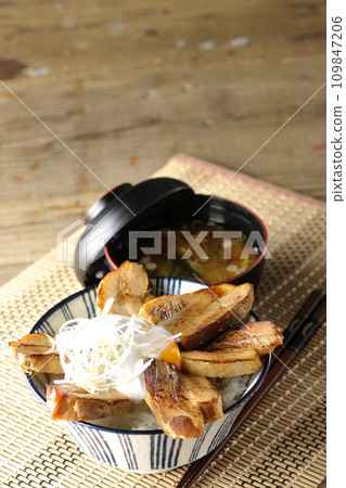 Thick-sliced roasted pork bowl topped with soft-boiled egg and miso soup 109847206