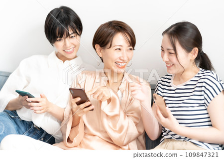 一個女人在沙發上用智慧型手機放鬆 109847321