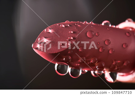 Red lipstick with water drops on a dark background. Red lipstick with water drops on a dark background. 109847710