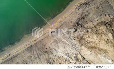 Aerial Contrast of a Verdant Shoreline and Barren Land 109848272