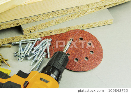 tools for repair and construction. Screwdriver, furniture screws, measuring tape, self-tapping screws, with a place for text. Top view tools for repair and construction. Screwdriver, furniture screws, measuring tape, self-tapping screws, with a place for text. Top view 109848733