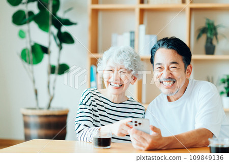 一對年長夫婦一起看他們的智慧型手機。 109849136