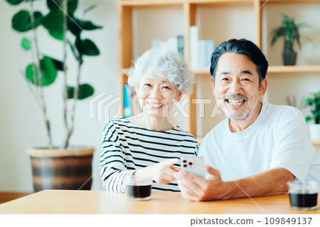 A senior couple looking at their smartphones together. 109849137