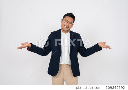 A doubtful, confused Asian businessman shrugging his shoulders, isolated white background. 109849692