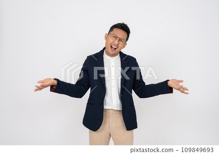 A doubtful, confused Asian businessman shrugging his shoulders, isolated white background. 109849693