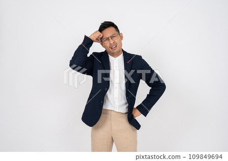 A doubtful, confused Asian businessman is standing on an isolated studio white background. 109849694