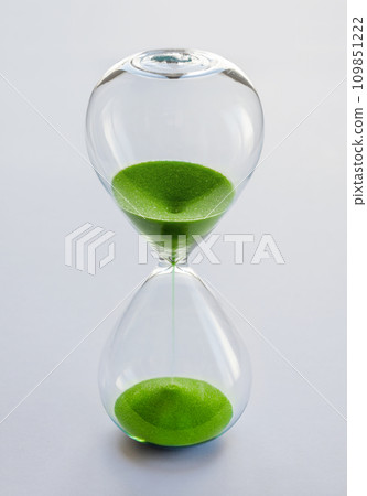Hourglass containing green sand isolated on white background 109851222
