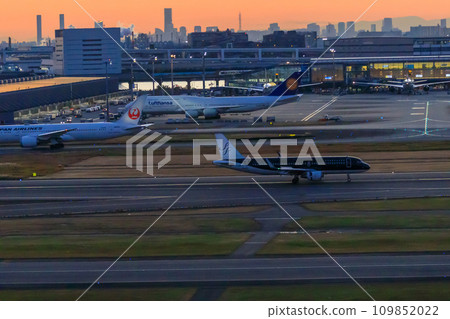 Haneda Airport bathed in the sunset, planes taking off and landing 109852022
