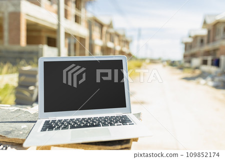 Computer laptop blank screen in construction site background for advertising builder engineer architect software design technology device. 109852174