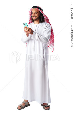 Young Arab man in traditional dress thobe using smartphone at white background Young Arab man in traditional dress thobe using smartphone at white background 109853108