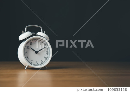 Time managment and Work management concept.Clock isolate on the wooden table and black background. 109853138