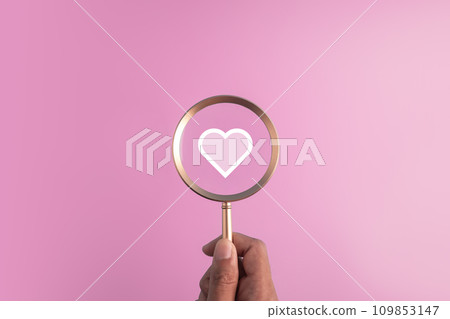 find love concept for Valentine day,marriage and romantic moment.red heart icon and hand holding the magnifier glass on pink background. find love concept for Valentine day,marriage and romantic moment.red heart icon and hand holding the magnifier glass on pink background. 109853147