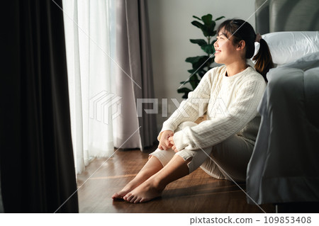 Happy woman sitting in the bedroom in the morning. Happy woman sitting in the bedroom in the morning. 109853408