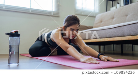 Young Asian woman meditating with trainer online at home Young Asian woman meditating with trainer online at home 109854226