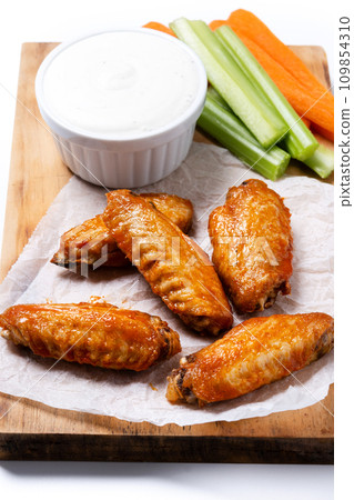Buffalo spicy chicken wings with cayenne pepper sauce isolated on white background Buffalo spicy chicken wings with cayenne pepper sauce isolated on white background 109854310