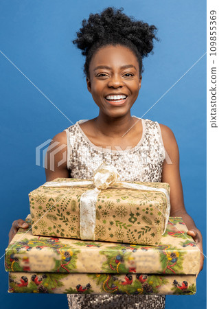 Pretty joyful young woman holding christmas gifts 109855369