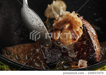 Fried fillet of beef with garlic and rosemary in a pan 109855979
