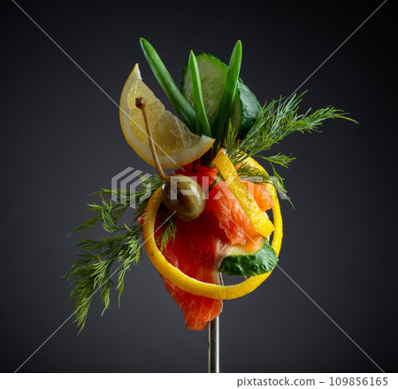 Smoked salmon with dill, cucumber, capers, green onion, and lemon slice. 109856165