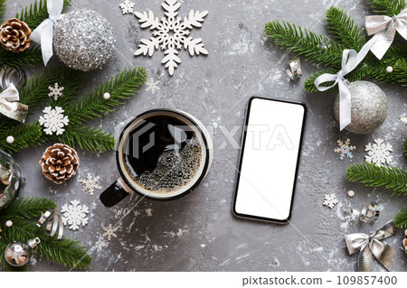 top view of smart phone with hot cup of coffee. Christmas decoration on colored background 109857400