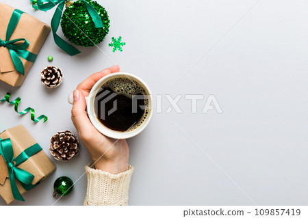 Woman holding cup of coffee. Woman hands holding a mug with hot coffee. Winter and Christmas time concept 109857419