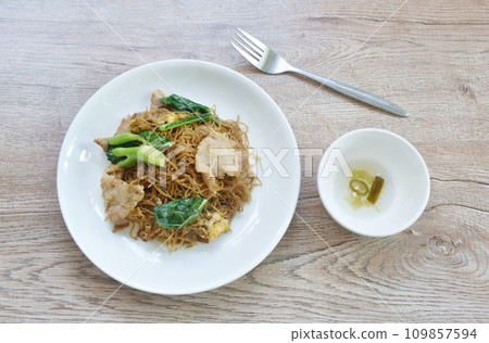 fried rice vermicelli noodles with slice soft marinated pork and Chinese kale in sweet black soybean sauce on plate fried rice vermicelli noodles with slice soft marinated pork and Chinese kale in sweet black soybean sauce on plate 109857594