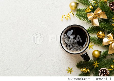 Delicious fresh festive morning coffee in a ceramic cup with little wrapped gifts, ornament and xmas toy. Cup of coffee and new year toys 109858121